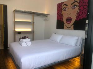 Sant Francesc de s'EstanyPAIISE Hotels的卧室配有一张白色床,墙上挂有绘画作品