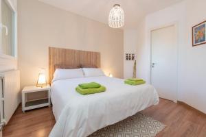索尔德乌Apartamento Fontargent 2的卧室配有一张白色大床和绿色毛巾