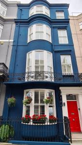 布莱顿霍夫布赖顿红蓝酒店的蓝色的房子,窗户上有鲜花