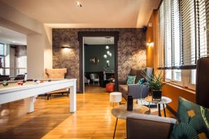 布尔日Logis Villa C Hôtel的客厅配有台球桌和椅子