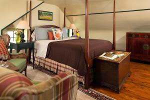 ParisAshby Inn & Restaurant的一间带天蓬床的卧室和一间客厅