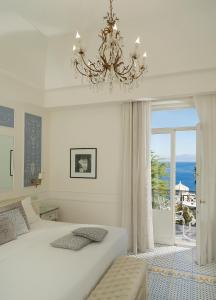卡普里埃克斯尔帕克豪华酒店的卧室配有一张白色大床和吊灯。