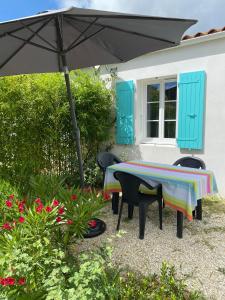 奥雷龙圣皮耶尔Le sable chaud的院子里伞下的桌子和椅子