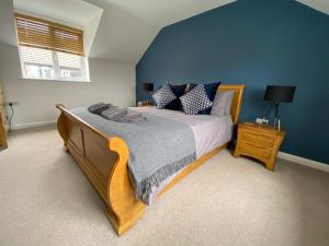 林肯Hygge Homes - Modern 1 bed house的一间卧室配有一张带蓝色墙壁的大床