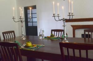 马特莱Sir John's Bungalow的餐桌,带2把蜡烛和桌椅