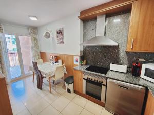 莱里达Agora Apartments的厨房配有桌子和炉灶。 顶部烤箱