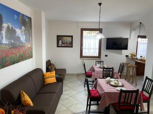 普蒂尼亚诺casa Belcolle的客厅配有两张桌子和一张沙发