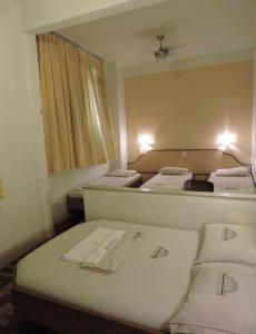 里约热内卢Hotel Belas Artes的小房间设有三张床和镜子