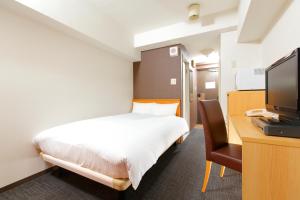 东京FLEXSTAY 白金旅馆的一间卧室配有一张床和一张书桌及电视