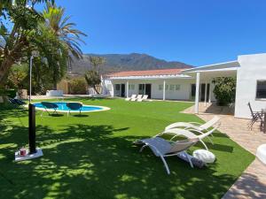 ArafoArafo Sunset Villa的一个带椅子的庭院、一个游泳池和一个房子