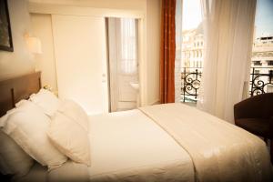 波尔图阿利多斯酒店的一间带白色床的卧室和一个阳台