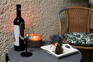 蒂米什瓦拉Rox Central Apartments 5的一瓶葡萄酒和一张桌子上的一杯