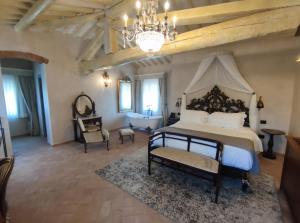 切雷托圭迪Villa Petriolo的一间卧室配有一张大床和一个吊灯。