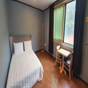 襄阳郡Bigso Stay的一间卧室配有一张床、一张书桌和一个窗户。