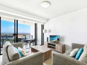黄金海岸Hinterland Views 2BR apartment - Sierra Grand的客厅配有两张沙发和一台电视机