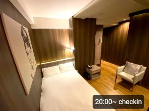 埼玉市Petit Hotel mio的配有一张床和一把椅子的酒店客房