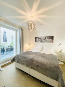 汉堡3-Raum Apartment Quartier57 Hamburg-Eppendorf的一间卧室配有一张大床和一个吊灯。