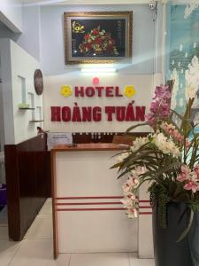 胡志明市Hoang Tuan Hotel的鲜花盛开的房间的红屯标志