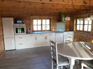 Tourville-la-ChapelleLe Chalet Caux-Marin的小屋内的厨房配有白色家电和桌子