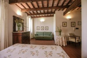 Isola d'AstiAgriturismo Bricco San Giovanni的一间卧室配有一张床、一张沙发和一张桌子