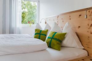 利恩茨Apart Rauchkofel的卧室配有带4个枕头的白色床