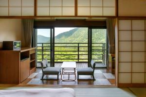 箱根箱根小涌园三河屋旅馆(Hakone Kowakien Mikawaya Ryokan)的客房设有桌椅和大窗户。