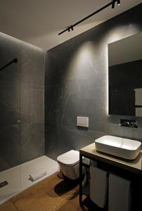 瓦伦西亚Fetén的一间带卫生间、水槽和镜子的浴室