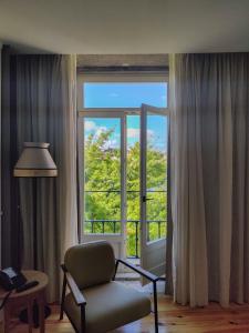 波尔图Memoria Porto FLH Hotels的客厅配有椅子和大窗户