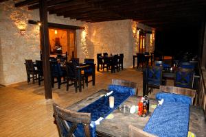 阿布达巴绿洲度假酒店的配有木桌、桌椅和桌子的餐厅