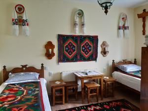 瓦杜伊泽Casa Muntean的一间卧室配有两张床、一张桌子和一张地毯。