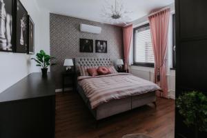 莱维采Apartmány Evia clinic的一间卧室配有床和一个带粉红色窗帘的窗户。