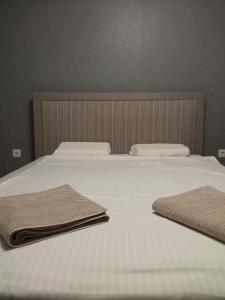索非亚Ultraviolet relax apart的一张白色的床,上面有两条毛巾