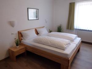科布伦茨祖尔帕法奈餐厅酒店的一间卧室设有两张带白色床单的床和窗户。