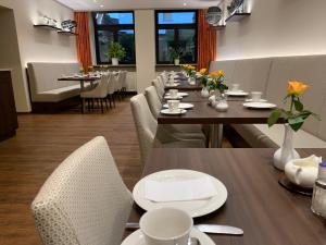 美因河畔法兰克福Hotel Hübler的用餐室配有长桌子和白色椅子