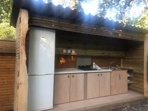 穆然Les roulottes de Bayama - logement insolite avec jacuzzi的户外厨房配有冰箱和水槽