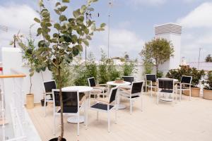 加的斯Plaza Mina Suites - Adults Recommended by Luxury Suites Cadiz的屋顶上带桌椅的天井