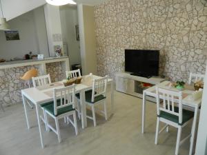 马泰拉A Casa di Anna - Locazione Turistica -的一间带桌椅和电视的用餐室