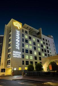 迪拜Jannah Marina Hotel Apartments的一座大建筑,晚上有标志