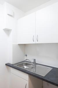 富尔达Leben im Herzen von Fulda的厨房配有水槽和白色橱柜