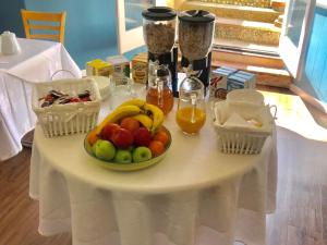 滨海韦斯顿海丽亚旅馆的一张桌子,上面放着一碗水果和两篮蜂蜜