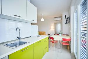苏佩塔尔Villa Grdelina的厨房配有黄色橱柜和桌椅