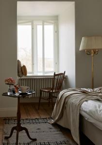 MusköArbottna Herrgård AB的一间卧室配有一张床、一张桌子和一个窗户。
