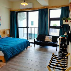 台东老余民宿的一间卧室配有一张床、一张沙发和窗户。