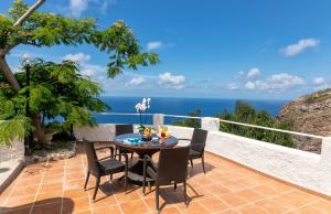 伊斯基亚Hotel Grazia alla Scannella的一个带桌椅的庭院和大海