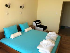 索佐波尔Family Hotel Littoral的一间卧室配有蓝色的床、蓝色枕头和椅子
