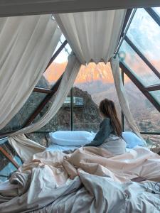奥兰太坦波Vertical Sky Luxury Suites的坐在帐篷里的床上的女人
