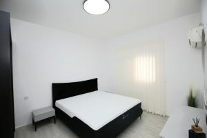 内坦亚City center luxury apartment in Netanya的一间卧室配有一张白色的床和黑色床头板