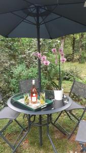 拉加里格La Bergerie的一张桌子,上面有一瓶酒,放在伞下