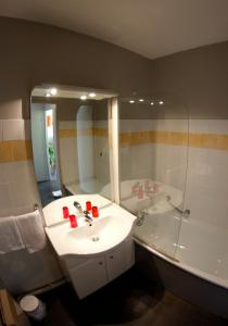 圣艾蒂安Appart'hotel Les Palatines的一间带水槽、浴缸和镜子的浴室