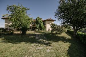 Isola d'AstiAgriturismo Bricco San Giovanni的前面有树木的院子的房子